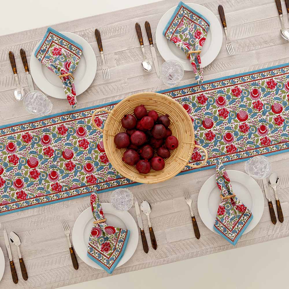 Table runner paired with matching napkin set on a dinner table. 