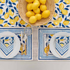 Napkin, placemat, and table runner with basket of lemons. 