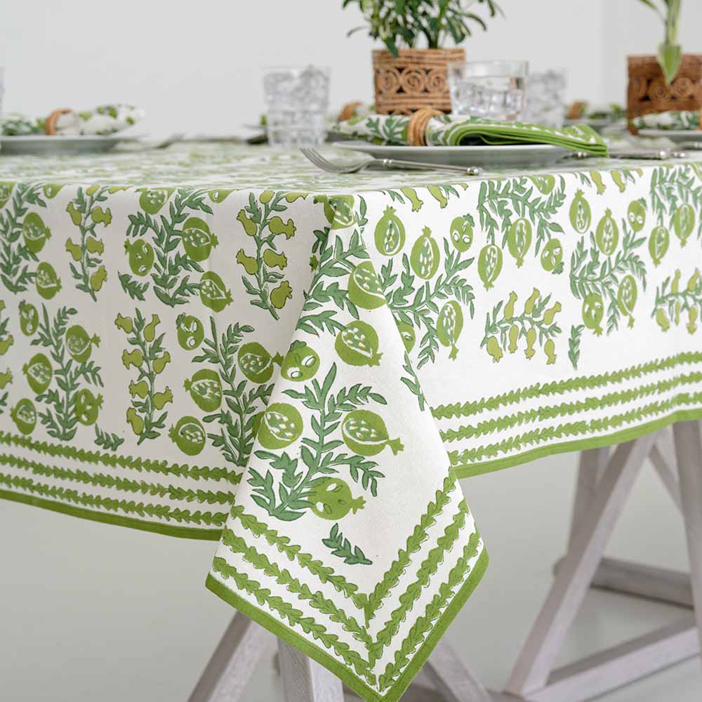 Corner shot of Pom Bells Green tablecloth with leaf border. 