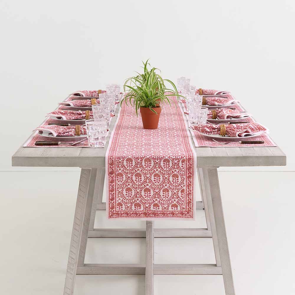 Dinner table beautifully set with Caroline Red patterned textiles. 