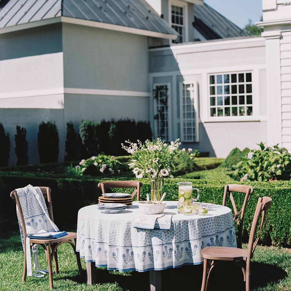 Outdoor round table decorated with Phlox Blue tablecloth. 