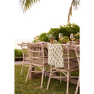 Tea towel set draped on the back of a chair at an outdoor dinner table. 