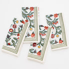 4 napkins folded as rectangles with floral pattern in shades of sage green, crimson, marigold and deep orange