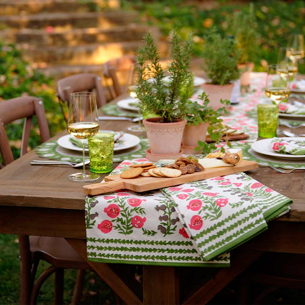 Tea towels on wooden table with charcuterie board. 