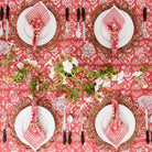 Overhead shot of Pomegranate Poppy tablecloth with matching napkins and floral decor. 