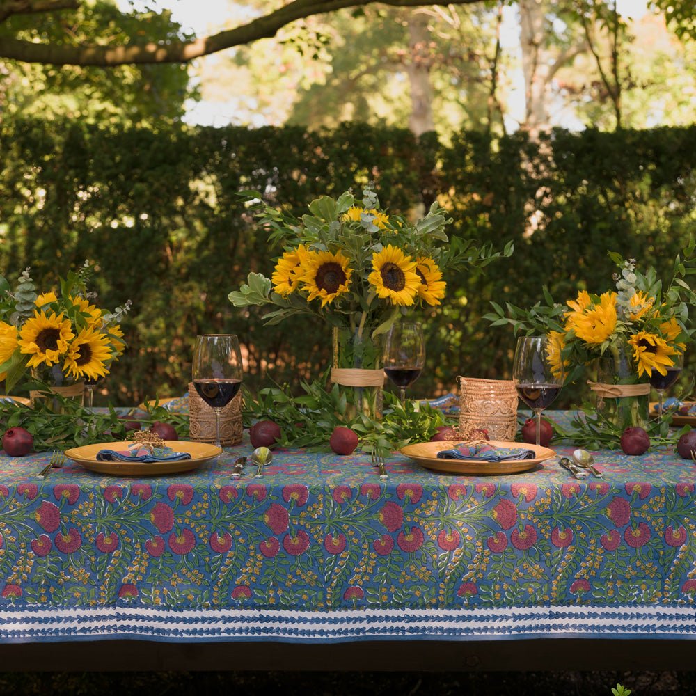 Cactus Flower Midnight Dark Blue & Magenta Floral Tablecloth outdoors set with yellow plates and sunflowers