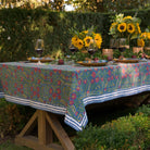 Cactus Flower Midnight Dark Blue & Magenta Floral Tablecloth outdoors set with yellow plates and sunflowers