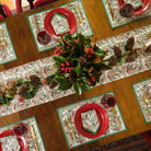 Christmas Garland placemats & napkins with red plates and matching table runner with pinecones and greenery