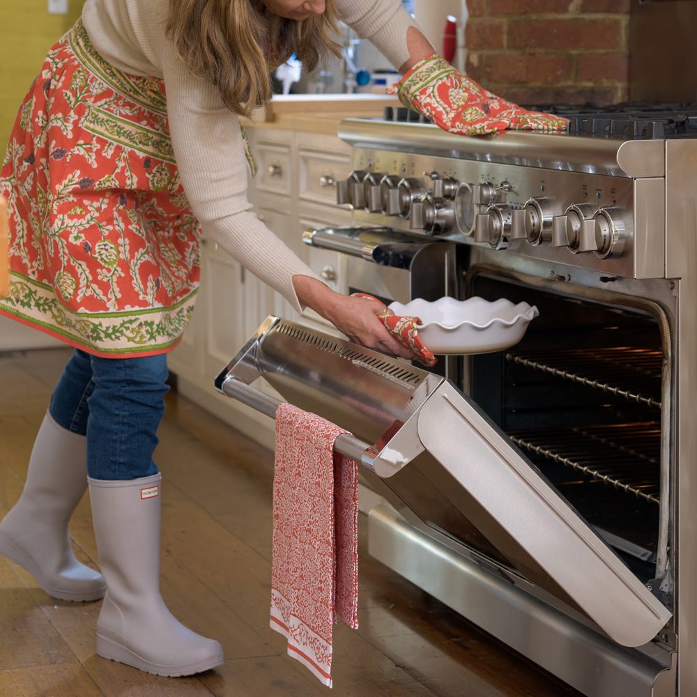 Model baking with Harvest Pinecone apron and oven mitts