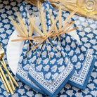 Pom buti denim napkins on white plate tied with wheat