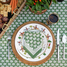 Pom Buti green napkin on plate and wicker charger on matching tablecloth