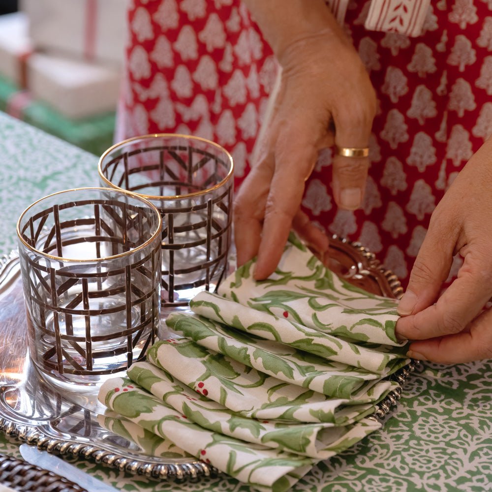 holly berry cocktail napkins on silver tray with brown bamboo bourbon glasses