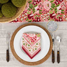 Folded napkin on white dinner plate paired with matching table runner. 