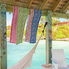 Crimson Blossom Table Runner collection hanging on beach cabana.