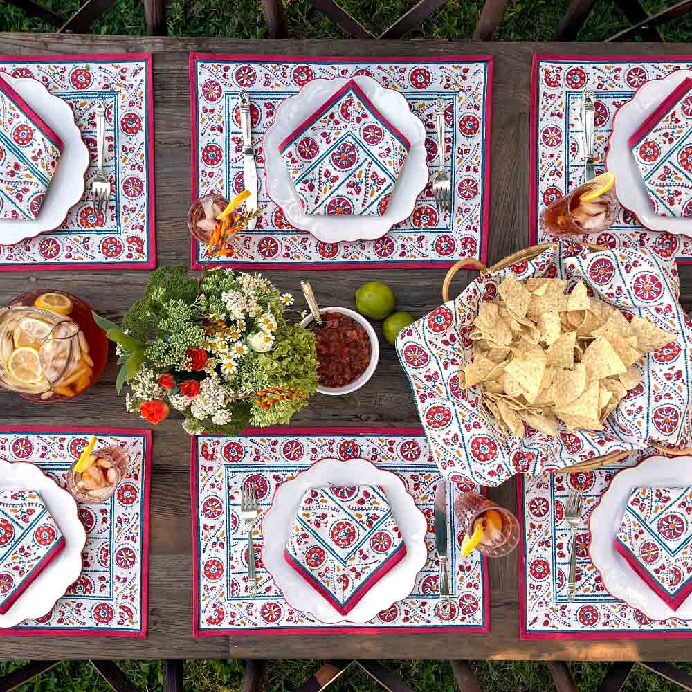 Bukhara Stripe Brick & Teal Napkin place settings on wooden table with flowers