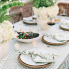 Napkins in napkin ring on plates with wine. 