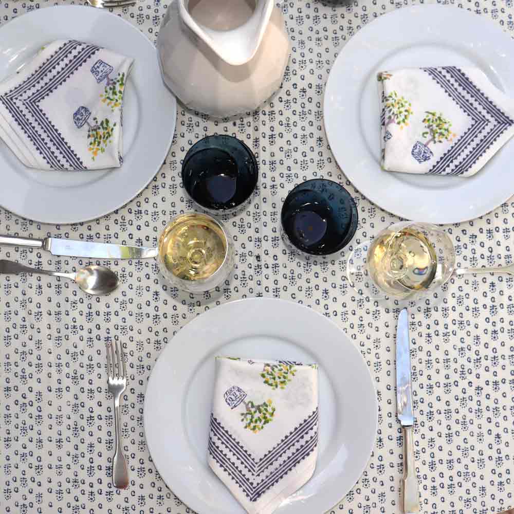 Lemon Topiary Napkin with place settings and tablecloth.