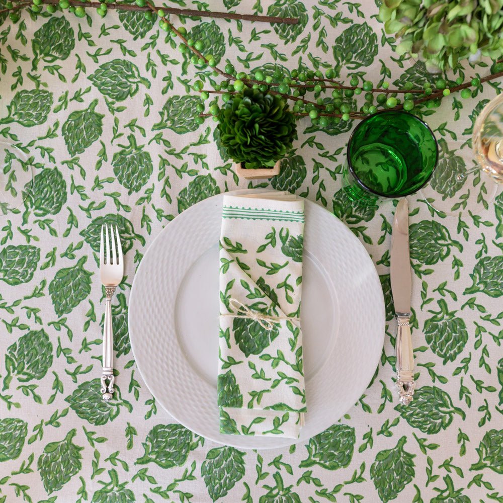 overhead of dancing artichoke green tablecloth with white plate and matching napkin